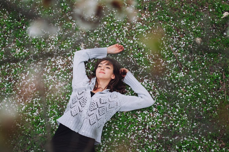 Woman lies in the grass, thinking about her breakup.