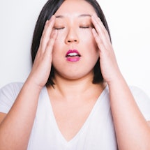 A woman with dementia and memory loss holding her head with her hands