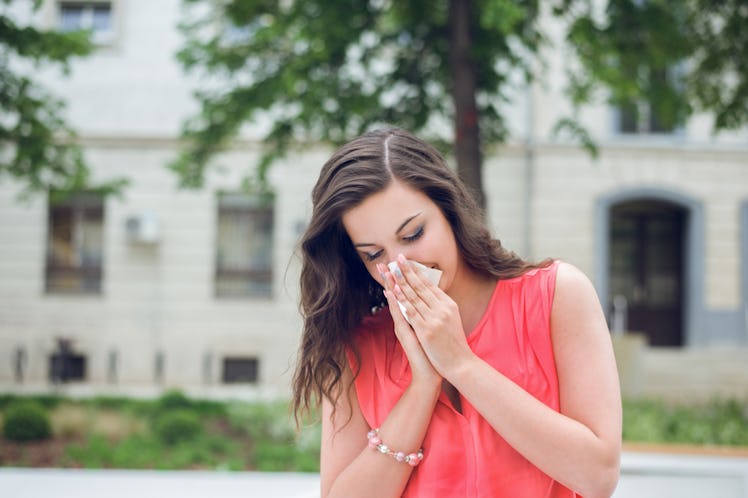 A young lady brushing her nose