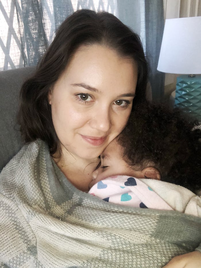 A mom holding her kid, counting down minutes until bedtime as the kid falls asleep