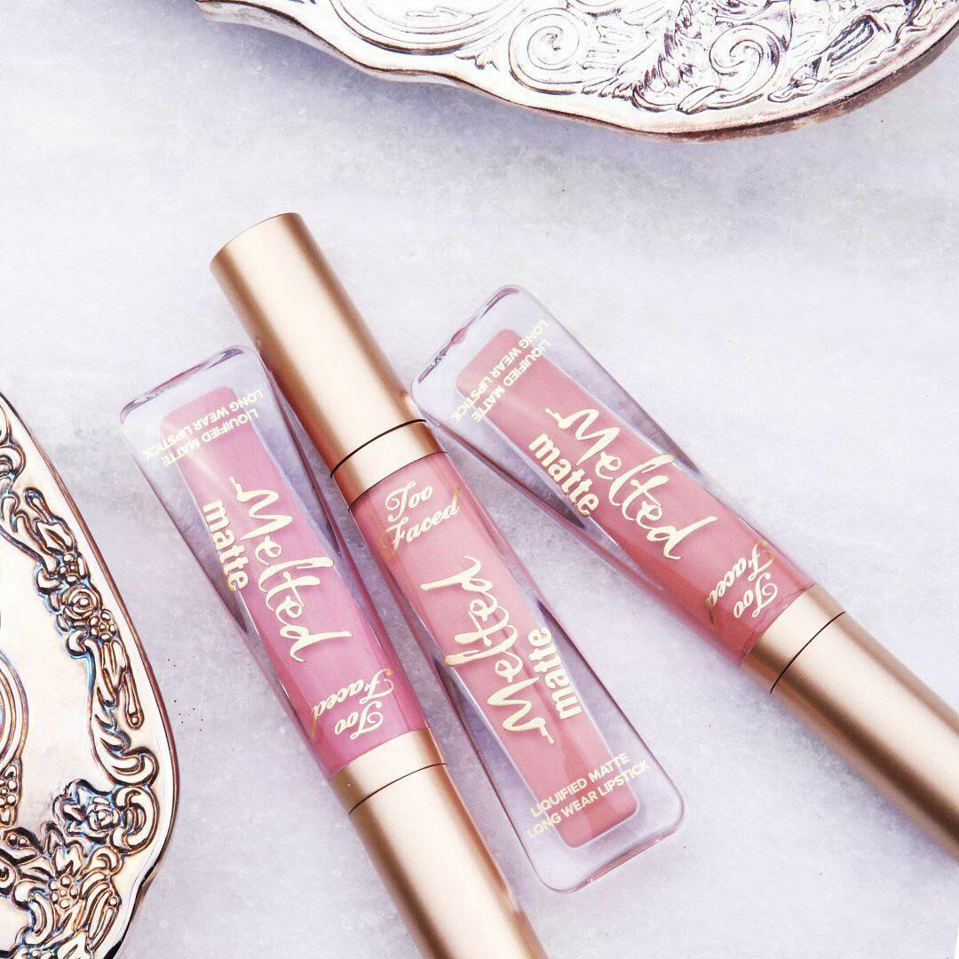 Pink Too Faced Melted Lipsticks on a table with a pink tablecloth