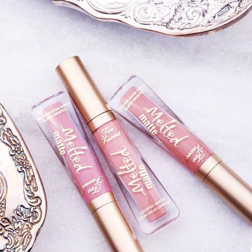 Pink Too Faced Melted Lipsticks on a table with a pink tablecloth