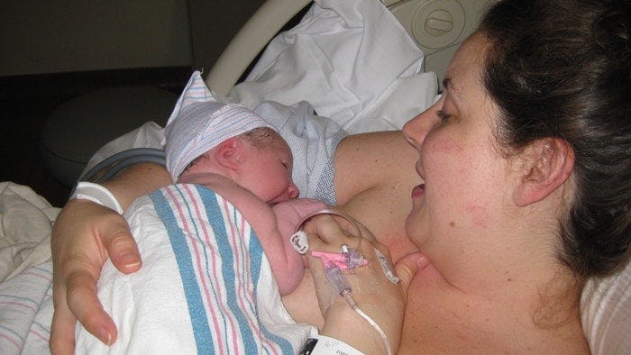 Maureen Shaw holding her newborn baby after getting her membranes stripped to induce labor
