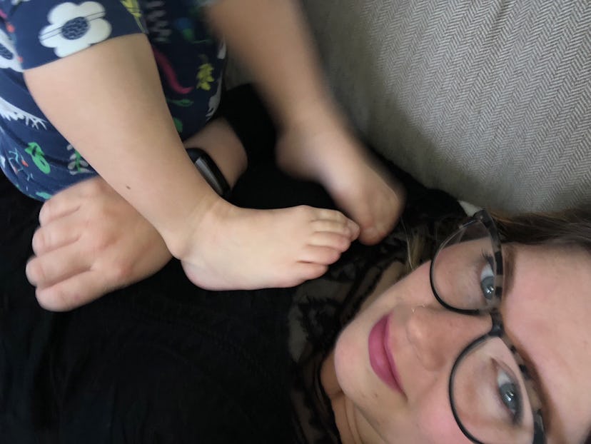Mary Sauer was lying on a sofa, and her kid put its legs on her shoulders 