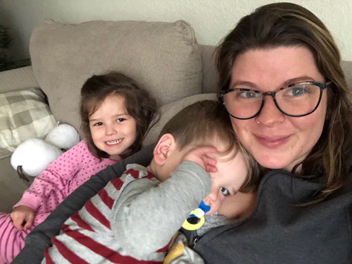 Mary Sauer with her two children sitting on the couch and smiling at the camera