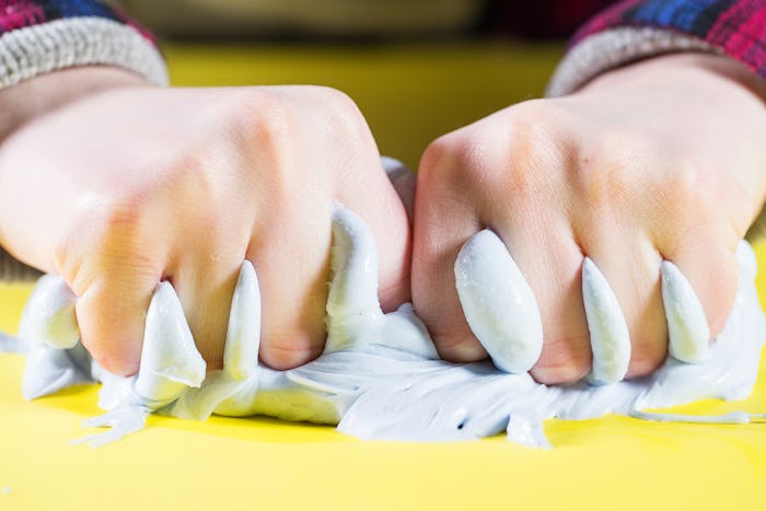 closeup of kid's hands squeezing slime