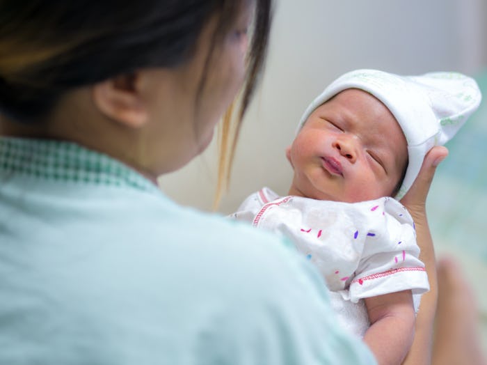 A nurse carrying a newborn baby