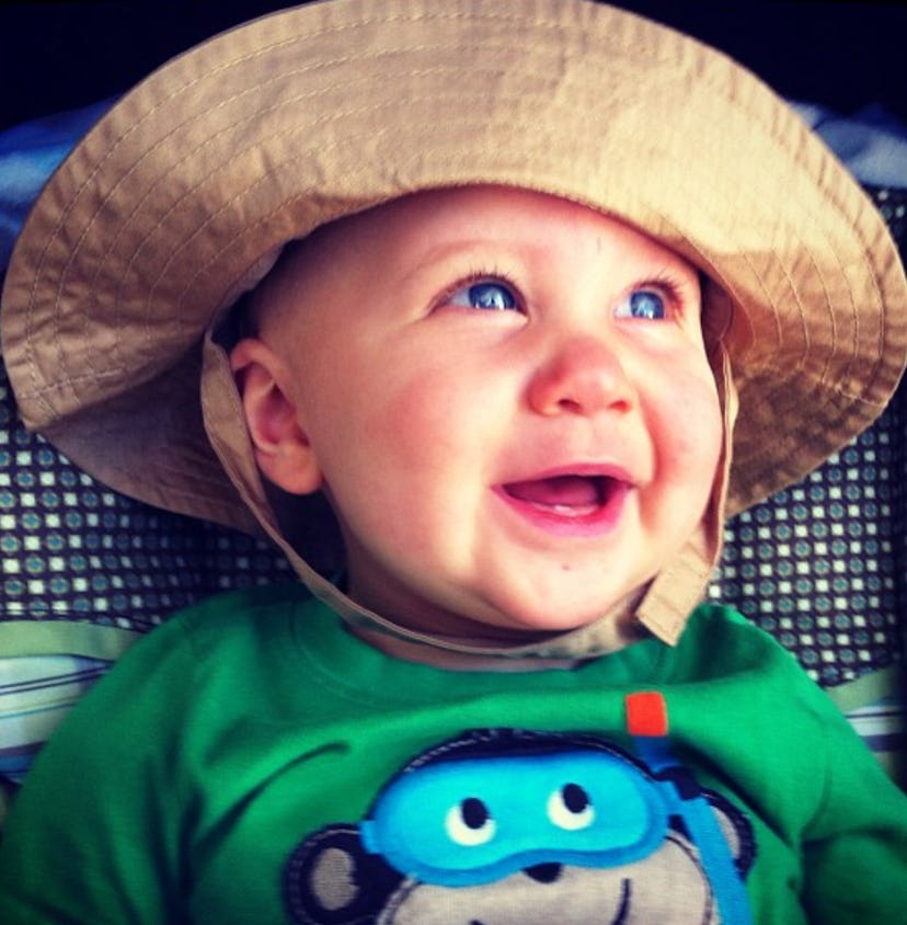 Candace Ganger's baby wearing a hat and smiling while the sun beams down on him