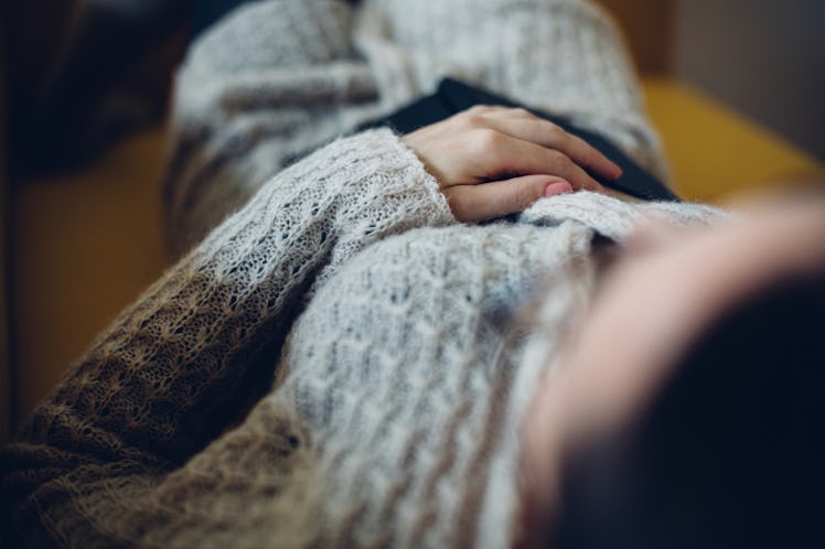 A woman lying and holding her stomach during her period