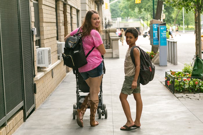 A mother walking with her kids and pushing a stroller