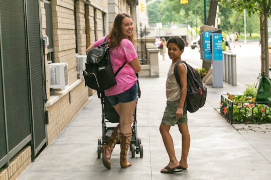 A mother walking with her kids and pushing a stroller