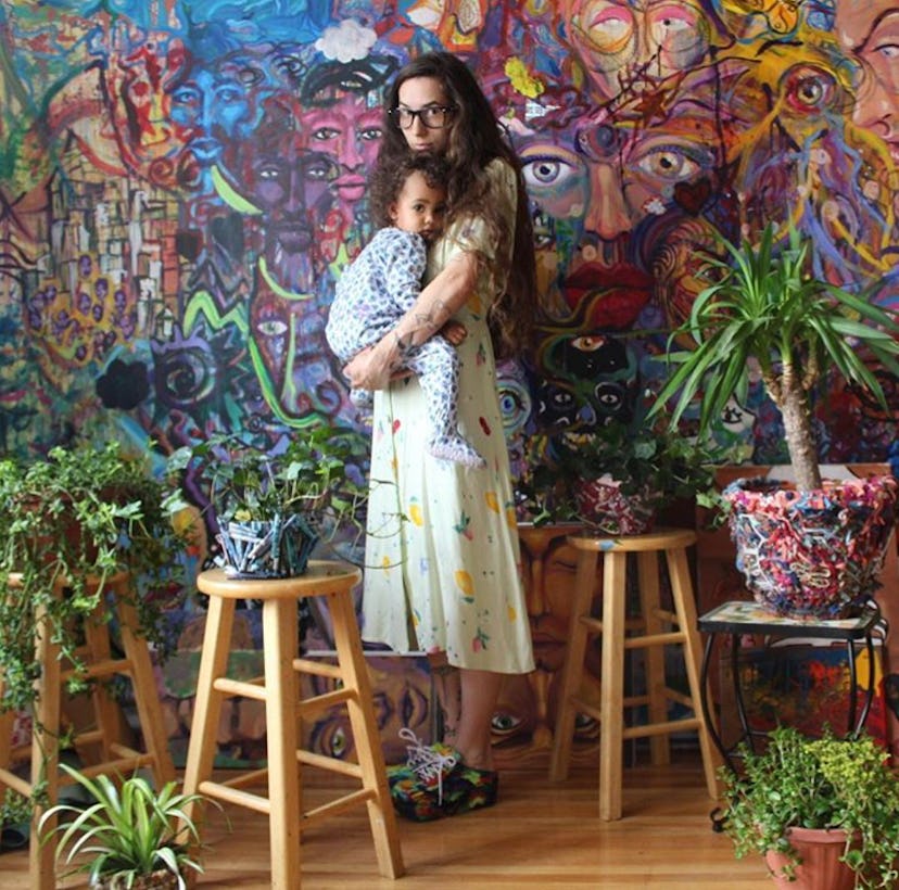 Katie Joy holding her daughter Frida in a room full of house plants