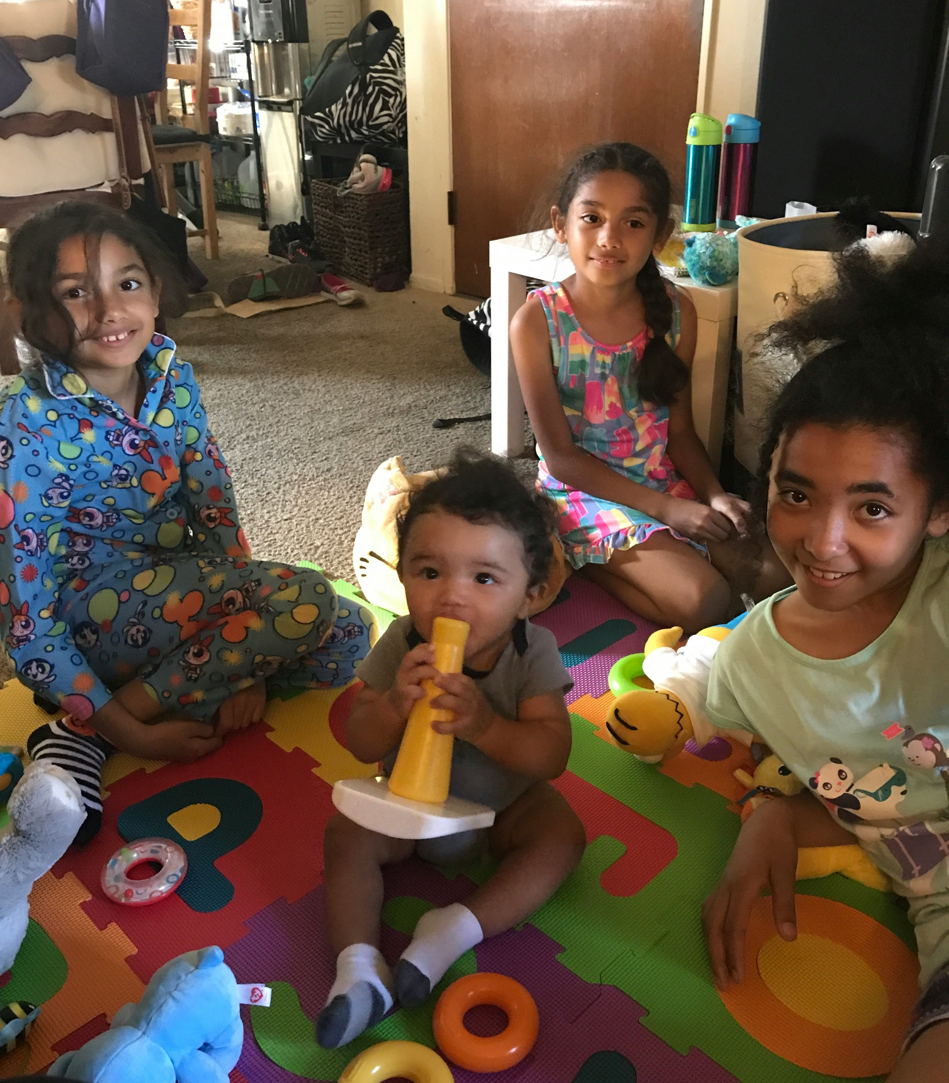 Angie Grace's four children sitting on the baby playmat.