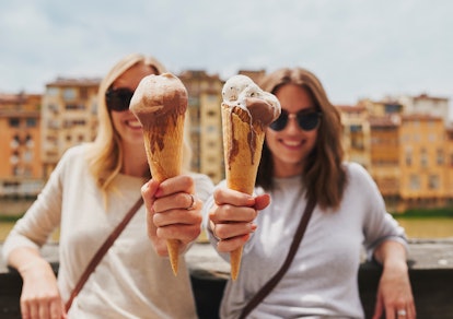 2 young women showing their ice cream cones before posting an ice cream caption on Instagram.