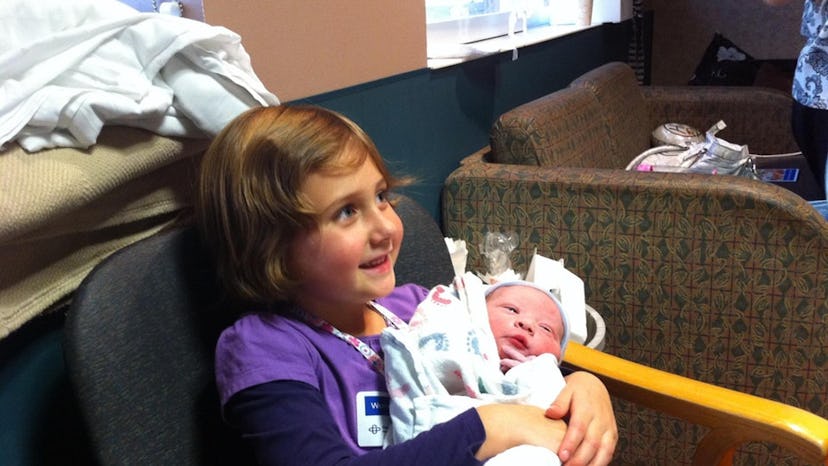 Candace Ganger's daughter holding her newborn baby sibling