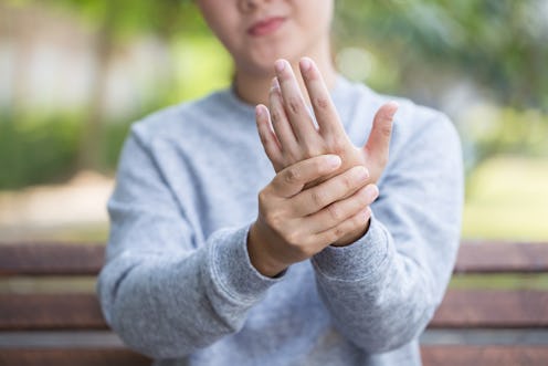 A girl massaging her left fist because of pain caused by arthritis