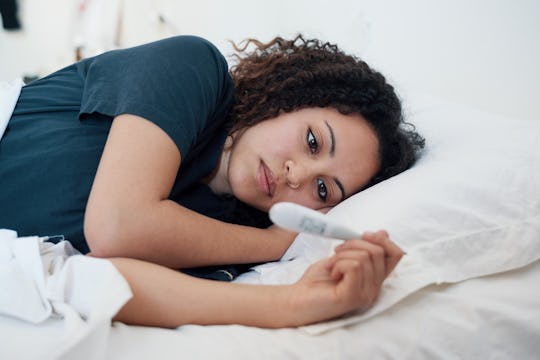 A woman looking at a pregnancy test, thinking about how stress can affect conceiving