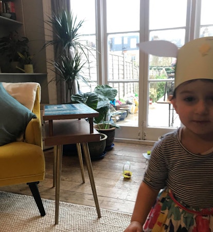 Elena, Dina Nayeri's daughter, with a house plant in her background