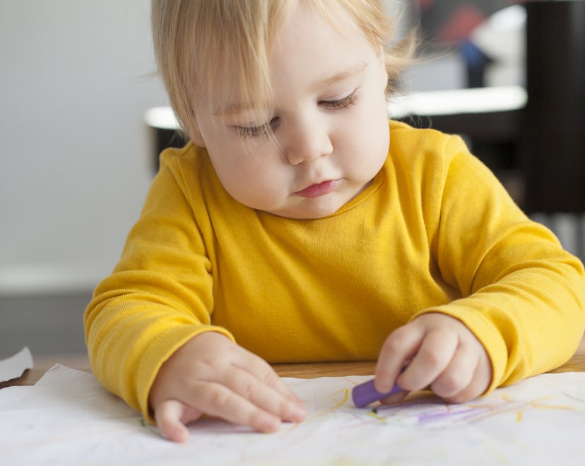 Toddler using crayons after munching on a box of them