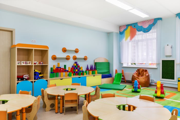 A day care's playroom with tiny tables and chair and toys