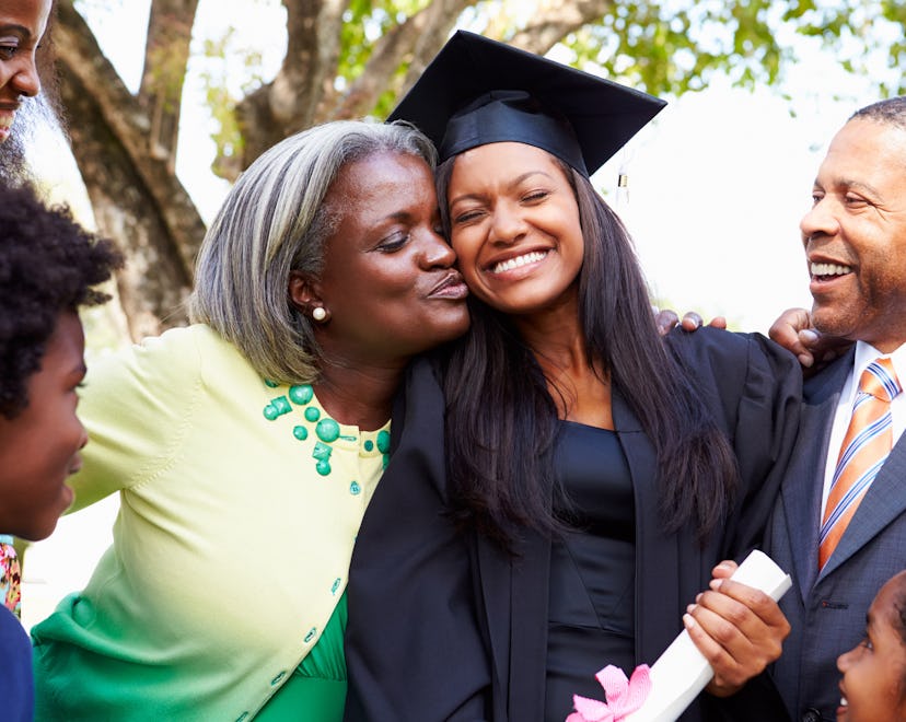 Parents hugging their college grad daughter