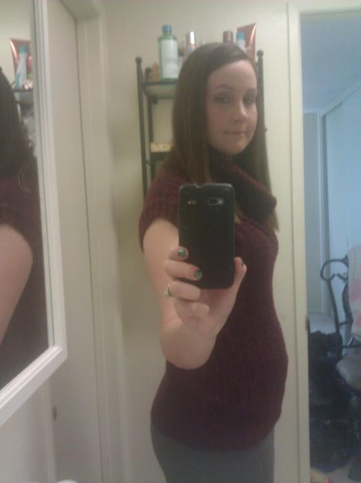 Pregnant Kristen Cervantes taking a selfie in front of a mirror