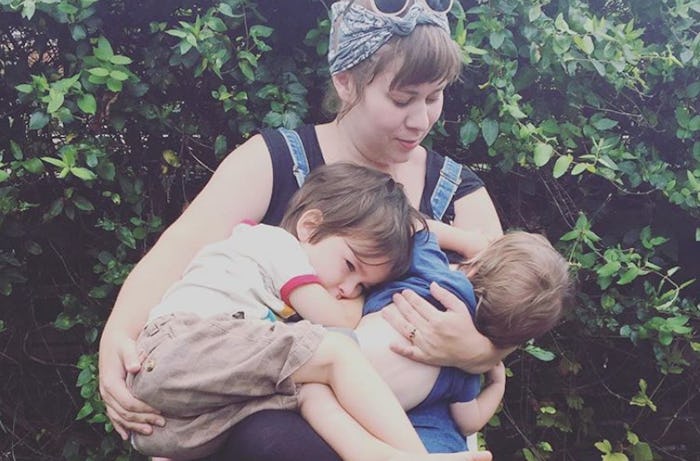 A woman who went through the baby transition, holding her two children in her arms