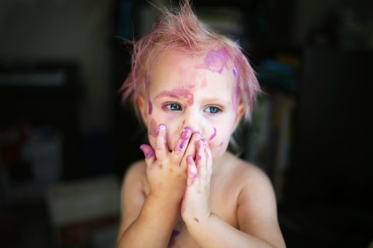 A baby girl with purple paint over her face