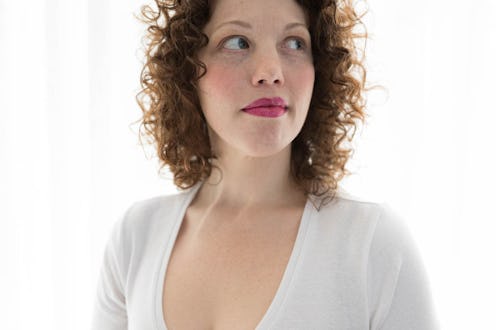 A curly brunette woman thinking about an abortion