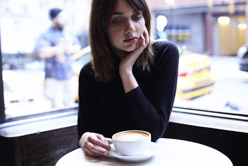 A woman sitting in a coffee shop contempating issues of abortion