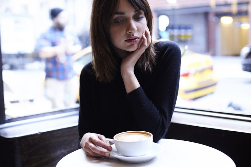 A woman sitting in a coffee shop contempating issues of abortion