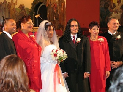 A wedding photo of a married couple and their family