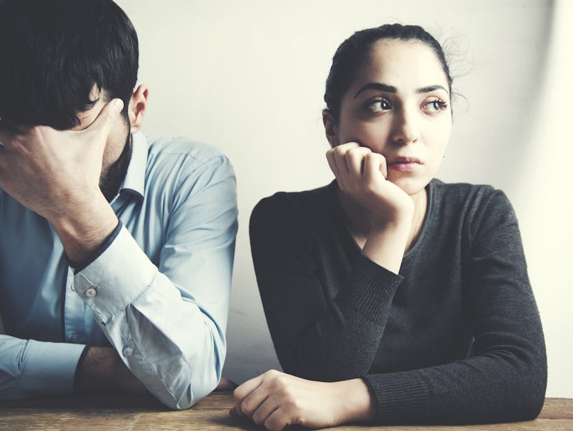 A couple sitting next to each other after having an argument regarding mom-shaming