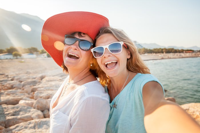 mom and daughter taking mother's day selfie outside