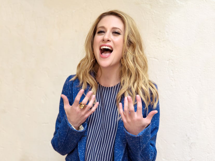 Caissie Levy singing on Broadway in a black-white striped shirt and blue blazer