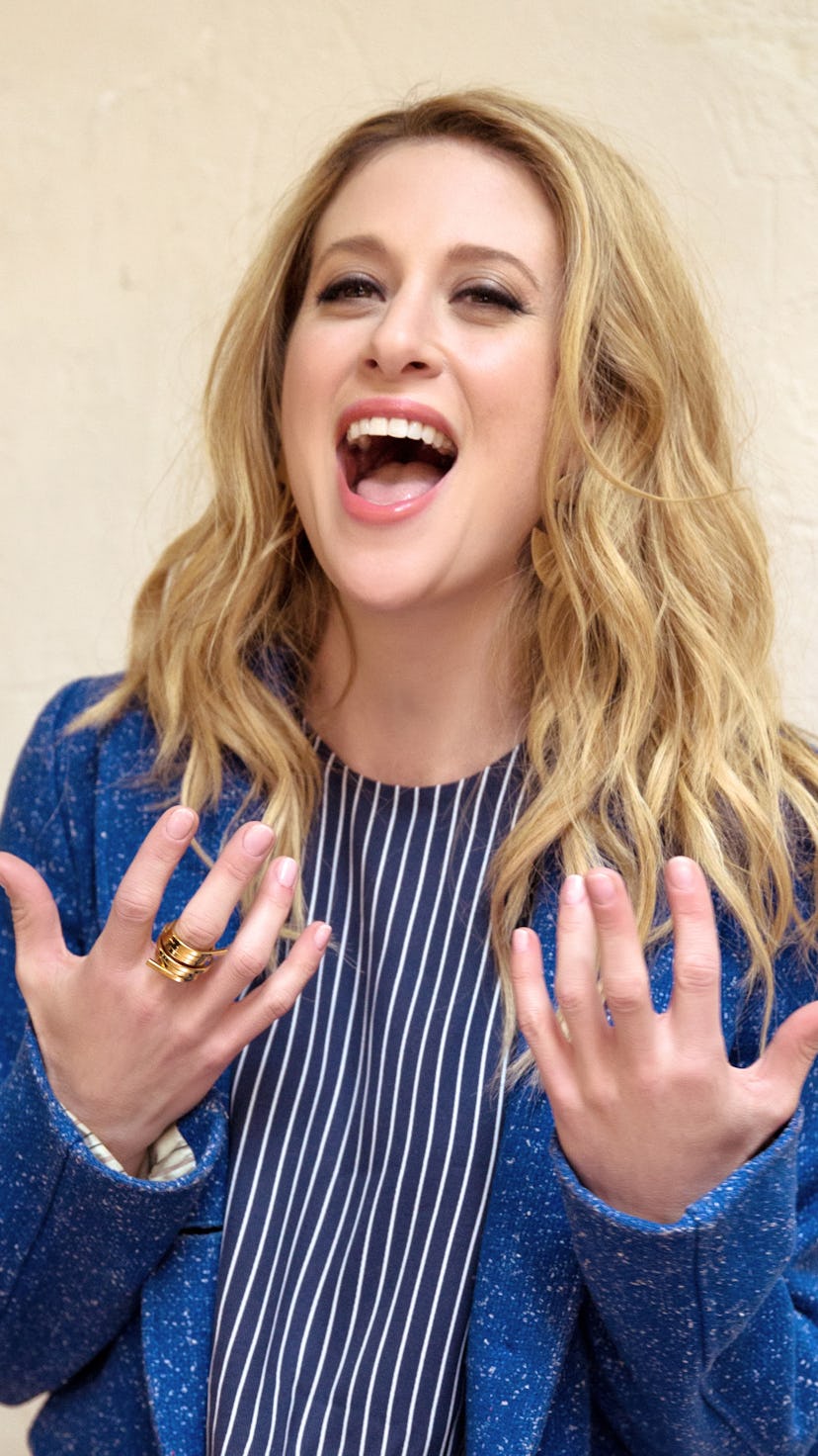 Caissie Levy singing on Broadway in a black-white striped shirt and blue blazer