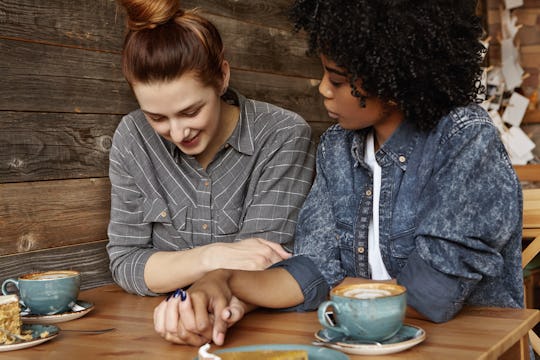 Two women sitting at a restaurant and one is supporting the other with Endometriosis