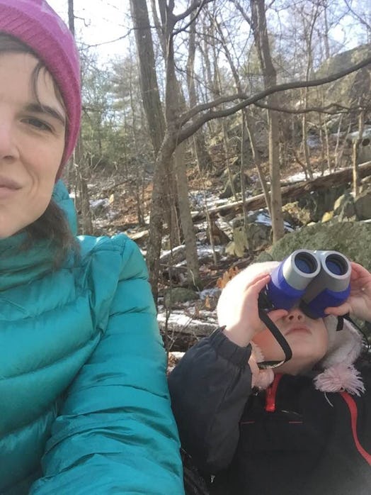 Mother taking a selfie with her daughter while she looks through the binoculars