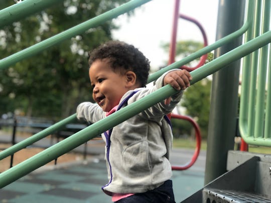 A little child running down the stairs of a slide at the playground