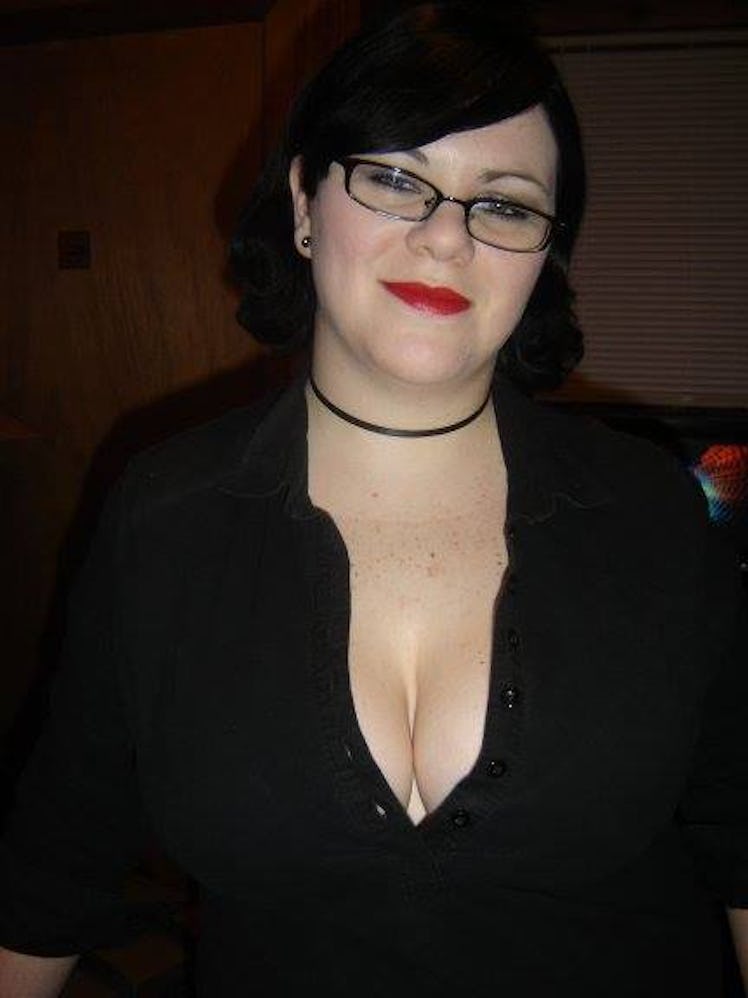 Woman posing for a picture wearing everything black and having red lipstick before breast reduction