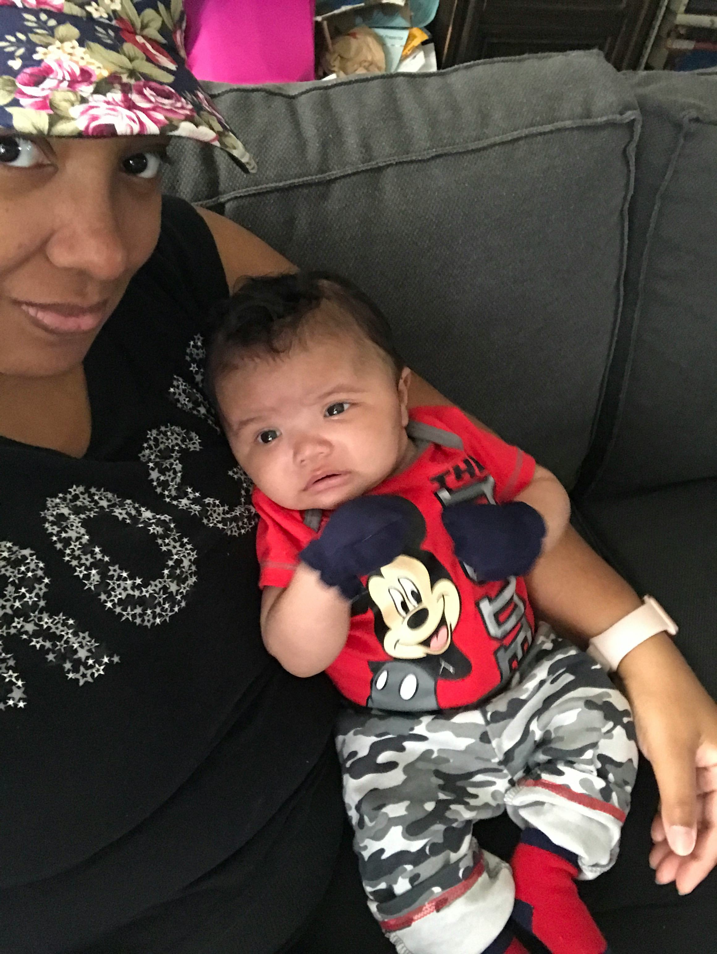 A mother posing with her newborn child for a photo