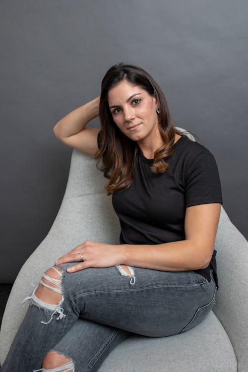 Alyssa Himmel sitting on a grey sofa.