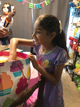 One of the twins from a family of six, opening her birthday present 