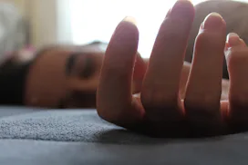 A tired woman with endometriosis lying on her bed