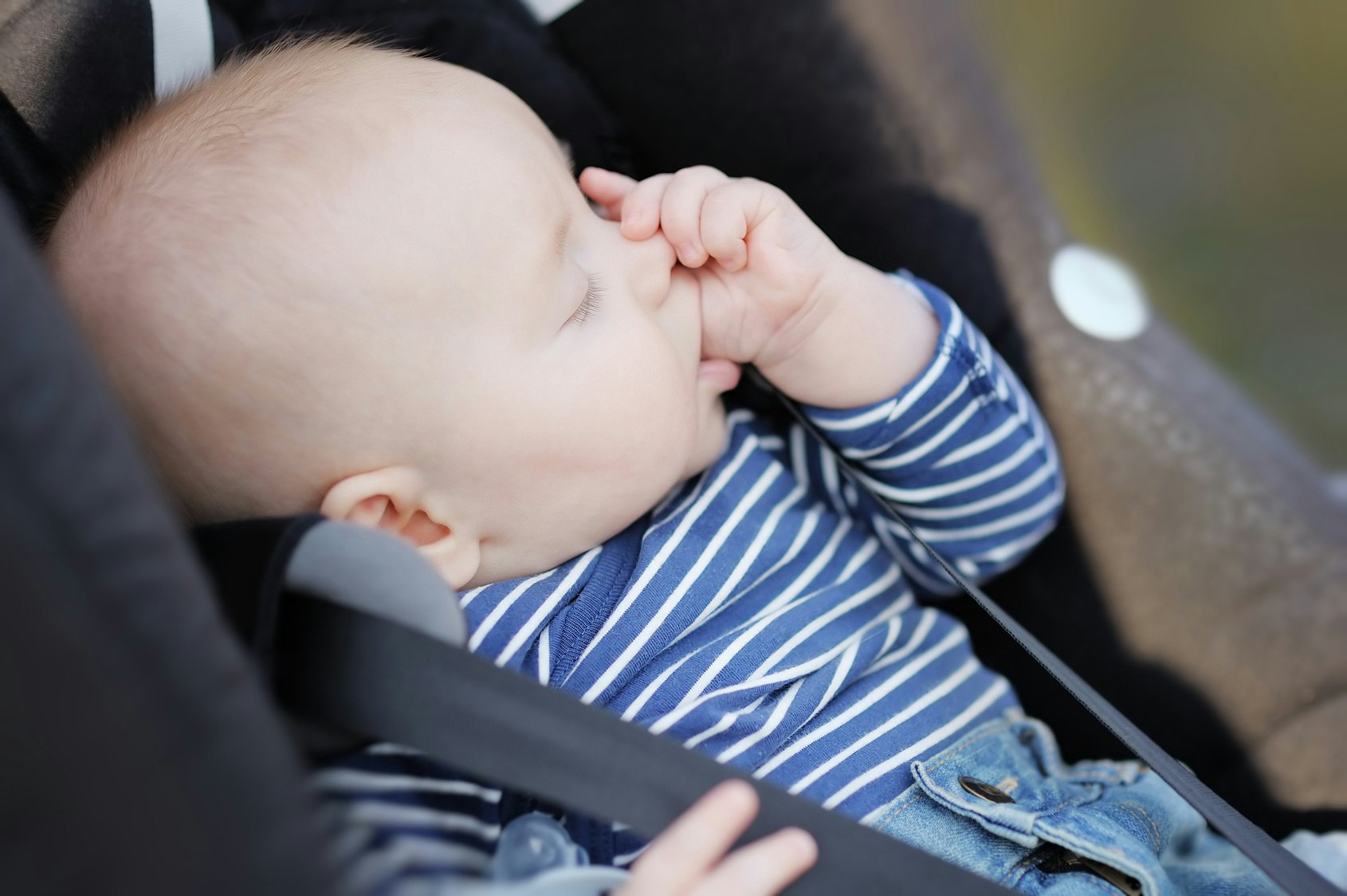 baby putting hands in mouth and vomiting