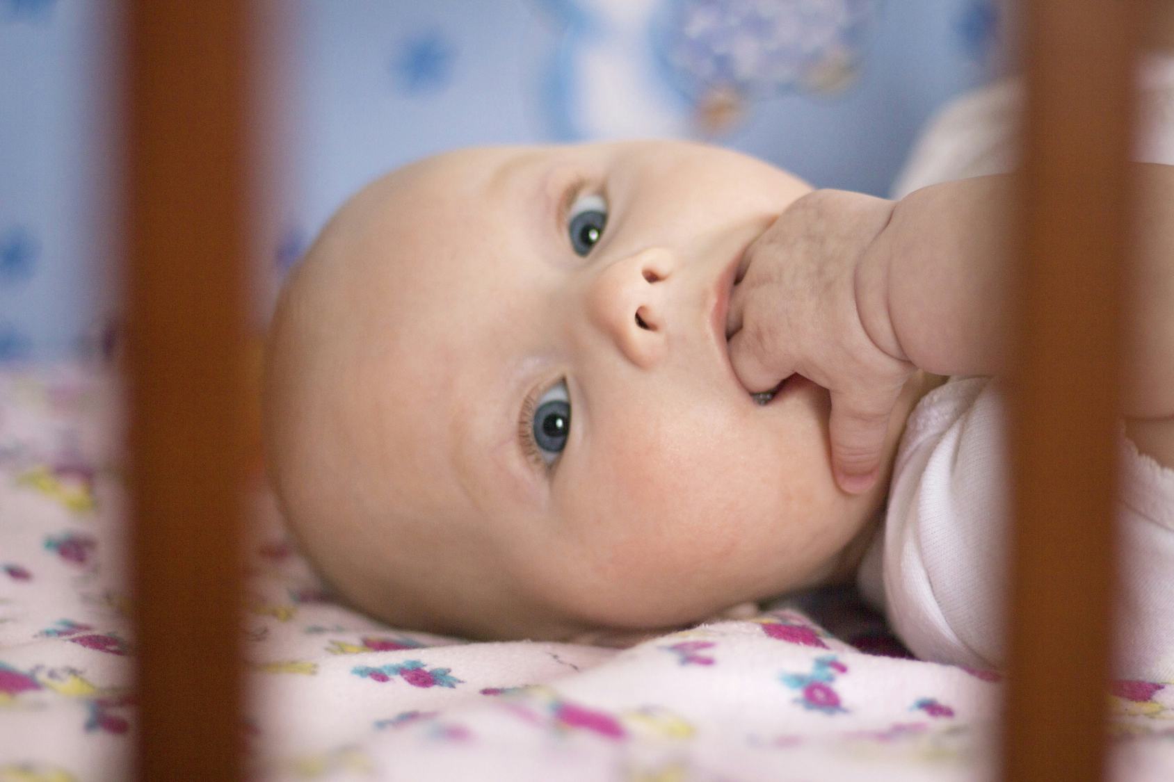 baby putting hands in mouth and vomiting