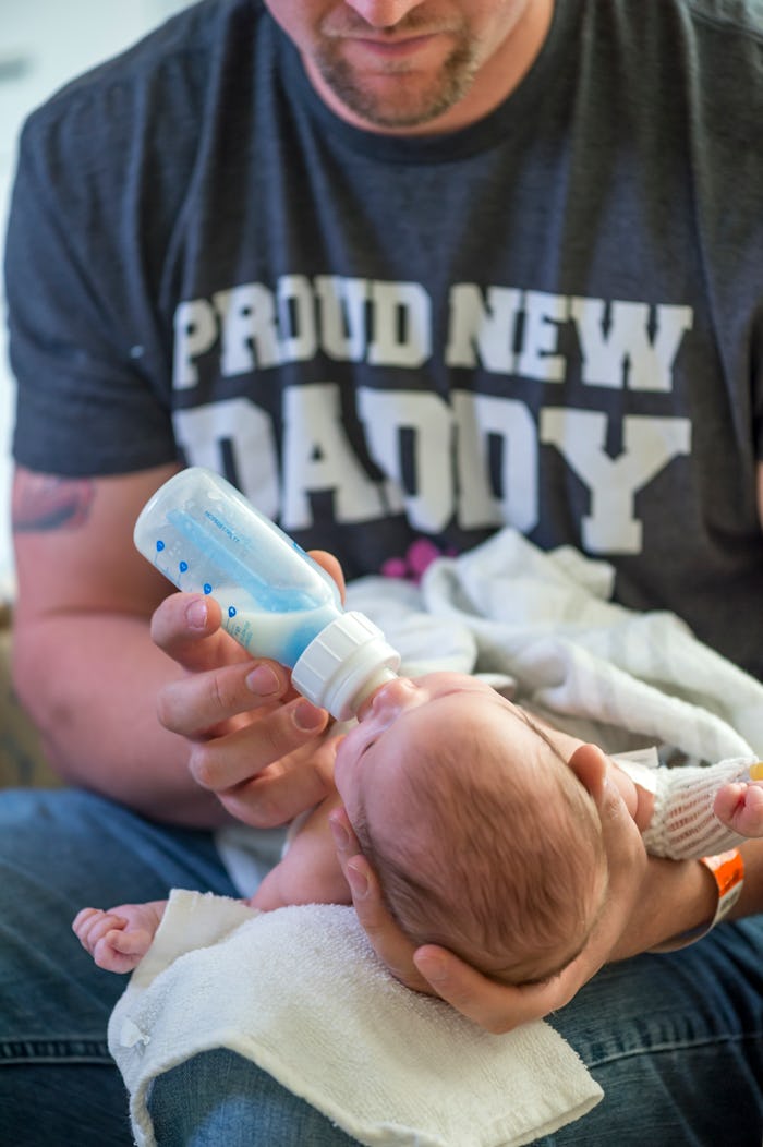A father giving milk to his baby from a bottle