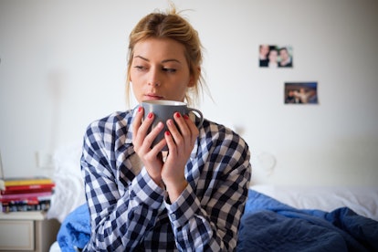 A woman drinks a mug of hot tea and honey, a way to fall back asleep after waking up at night