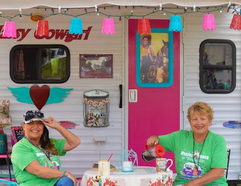 Two members of the 'Sisters on the Fly' sitting in front of a vintage trailer