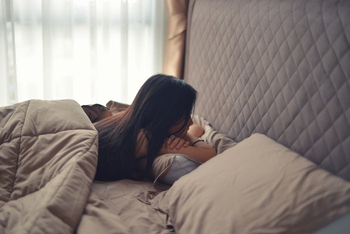 A woman lying stomach-down in her bad and has an eating disorder